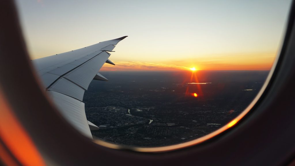 Airplane window showing sunrise