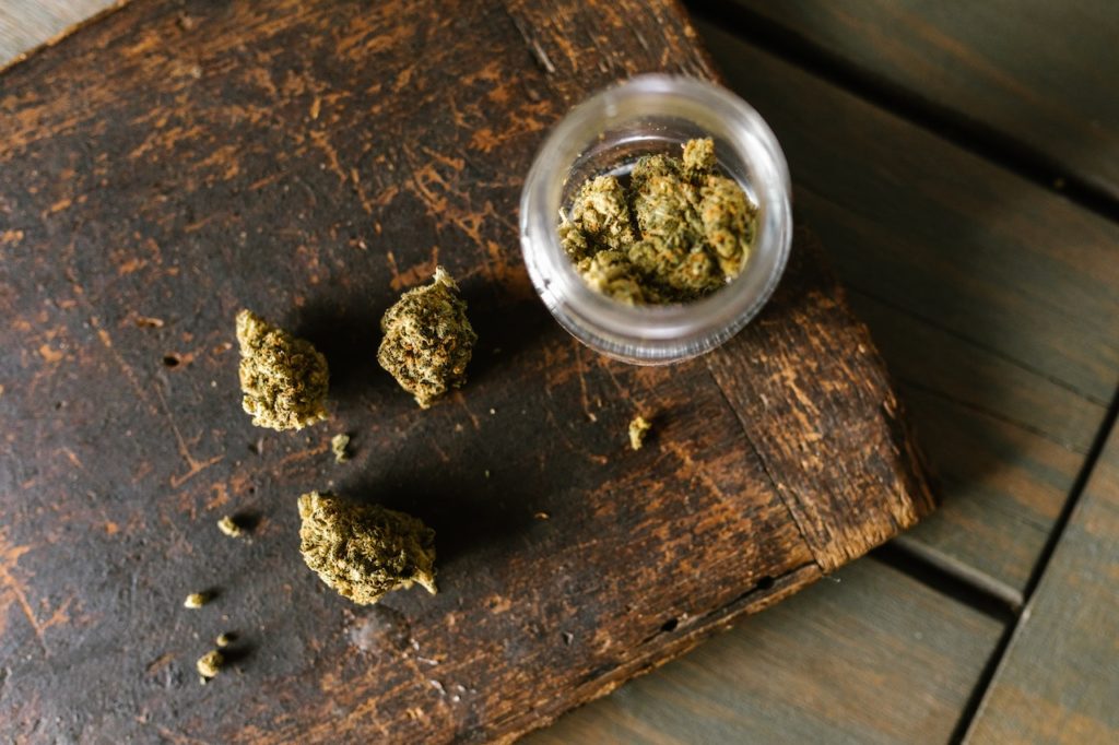 Cannabis in a glass jar on a wooden surface