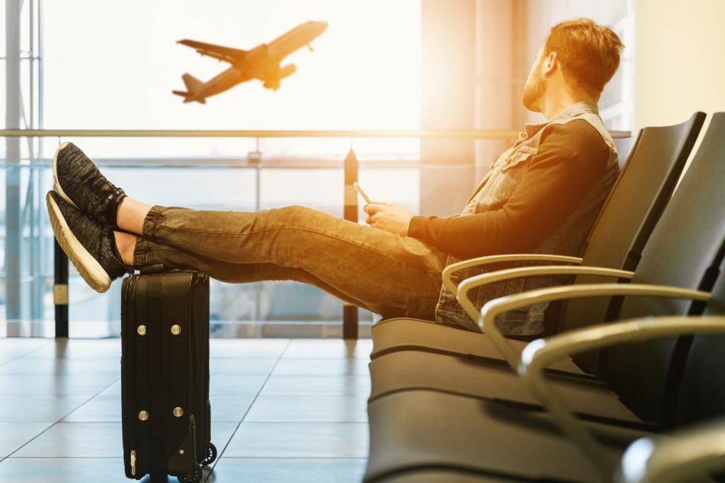 Man sitting in airport watching plane take off
