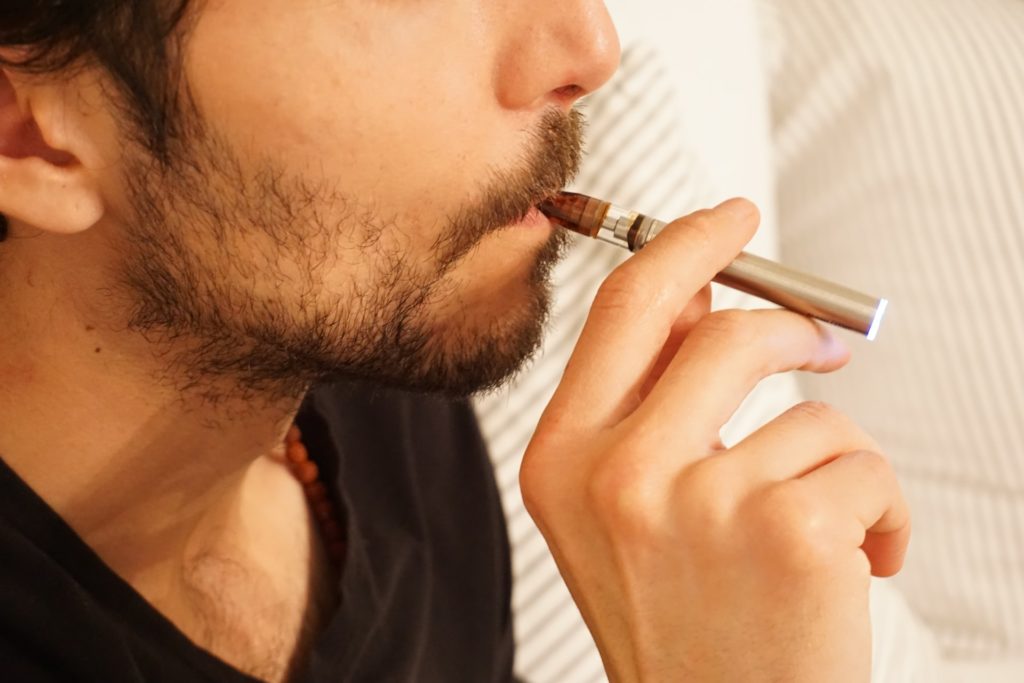 Man using vape pen and cartridge